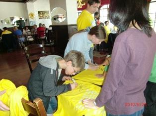 黄色いティーシャツにメッセージを書いているホストファミリーの写真