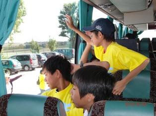 バスの中から手を振っている生徒たちの写真