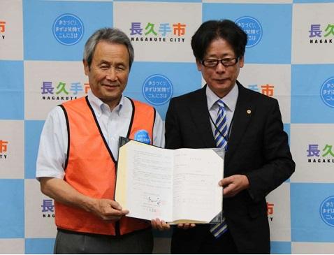 締結式にて長久手市の代表と愛知県社会保険労務士会の代表が協定書を一緒にもって記念撮影している写真