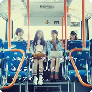 女の子が4人バスの一番後ろの席に並んですわり話をしている写真 みんなで一緒にバス旅行。楽しさも、CO2も シェアできる。