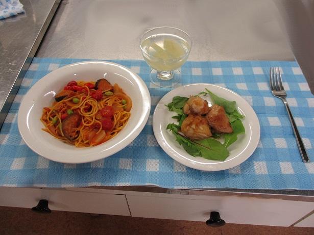 テーブルにセッティングされた夏野菜の煮込みパスタとチキンソテー、桃のゼリーの写真