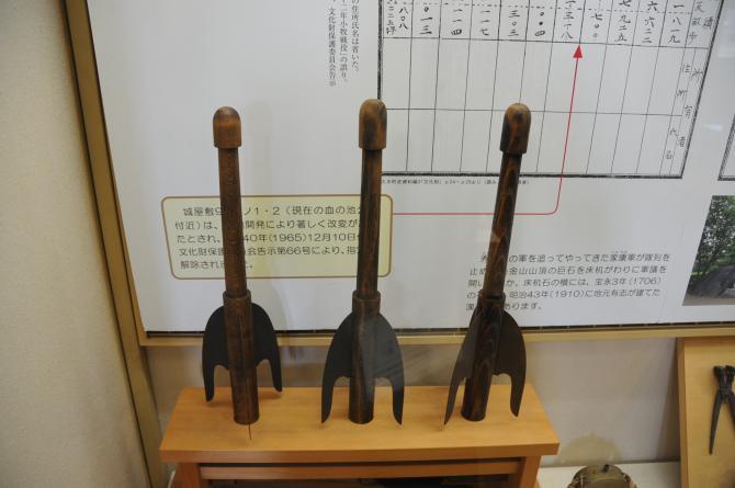 三脚のように足が3つに分かれている棒火矢が3つ台の上に展示されてある写真