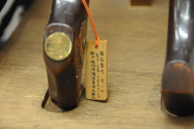 火縄銃の持ち手の部分と木札が写っている写真