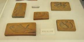 魚の形など板を掘って作られたオコシモンの型5種類の写真