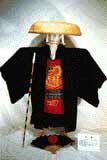竹傘に着物の中が明るい赤色の腹巻をした祭事用のオマント衣装の写真