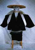 竹傘に黒色の着物に白色の紐で袖を上げた状態の馬囲い用のオマント衣装の写真