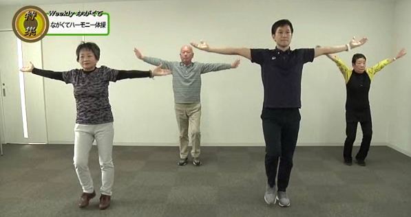 両手を横に肩の高さに広げて、ながくてハーモニー体操をしている動画の一部の写真