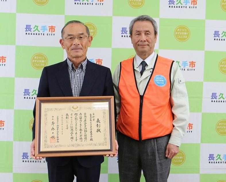 シニアクラブ連合会の男性が額に入った賞状を手に持って、市長の横に立っている写真