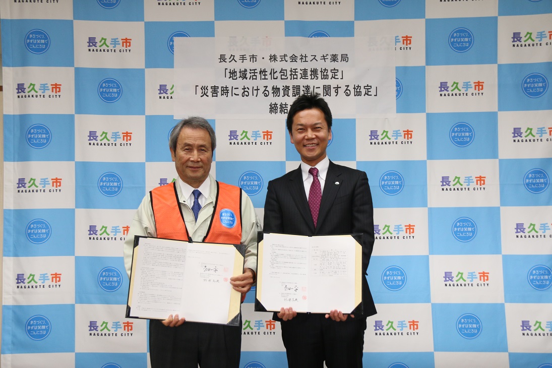 長久手市長と株式会社スギ薬局の代表が協定書を持って記念撮影している写真