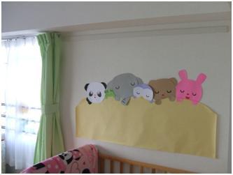 壁に眠っているパンダ、像、フクロウ、クマ、ウサギの切り絵が貼ってある写真