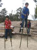 手作りの竹馬に乗って遊んでいる子供たちの写真