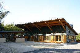 斜め屋根部分に4つの丸太が使用されている木造建物の写真