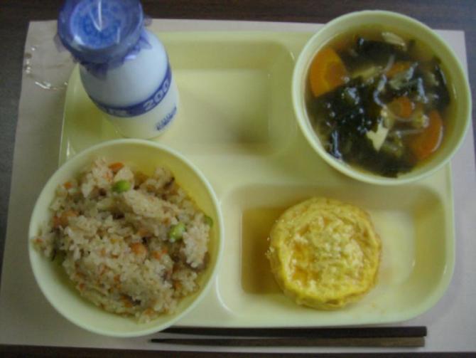 給食トレーの上に中華おこわ、フーヨーハイ、豆腐とわかめのスープ、牛乳が置いてある写真