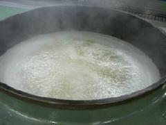 大きな釜で大量の大豆を煮ている写真