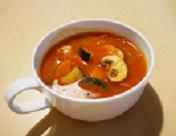 白いカップに入ったズッキーニのトマトスープの写真