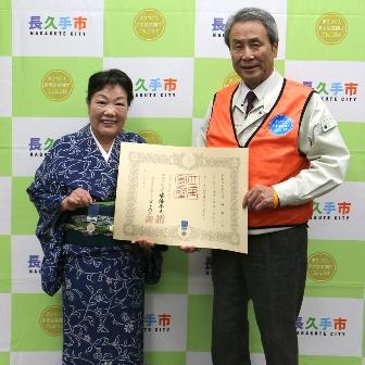 酒井都子さんと市長が賞状を持って広げて見せ、笑顔で並んで写っている写真
