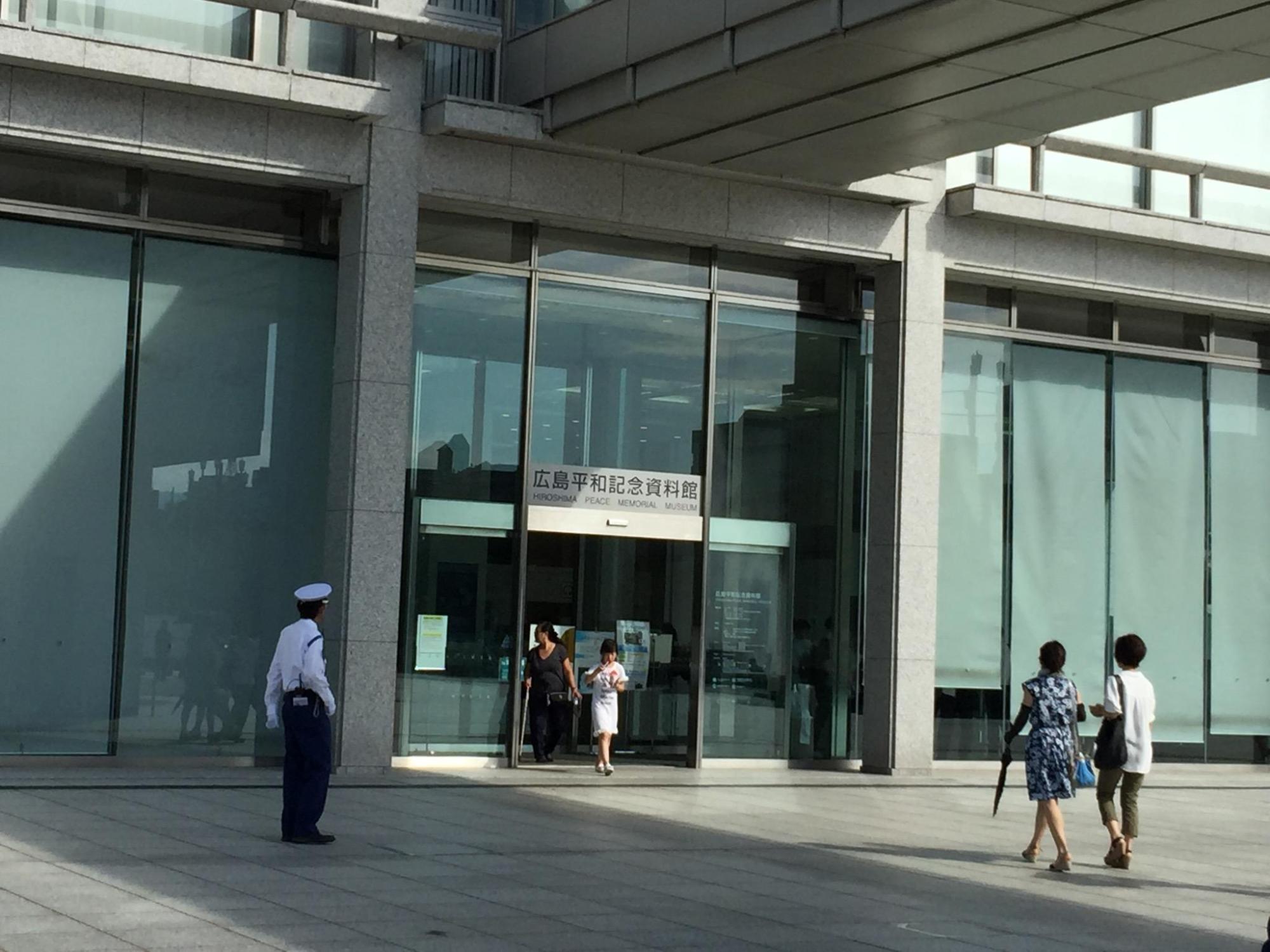 広島平和記念資料館の玄関前で入館者と警備員が写っている写真