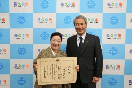 総務大臣表彰を受賞した酒井都子さんが賞状を手に持って笑顔で市長と写っている写真