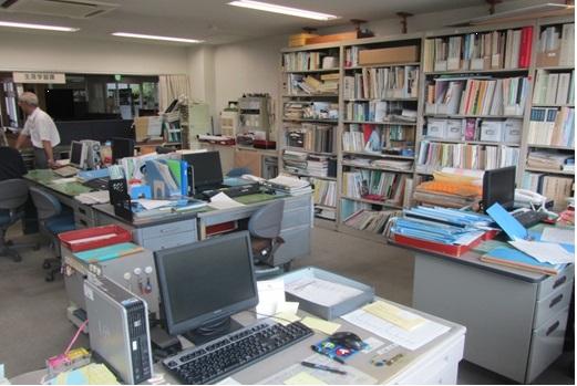 デスクの上にパソコンや沢山の書類が置いてある生涯学習課事務室の写真